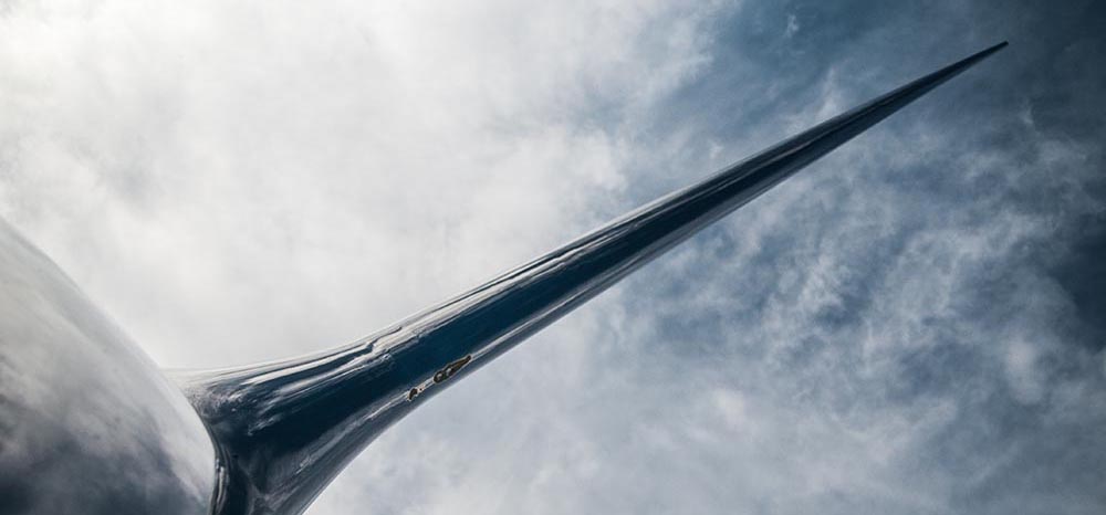 eine metallische Spitze ragt in den bewölkten Himmel