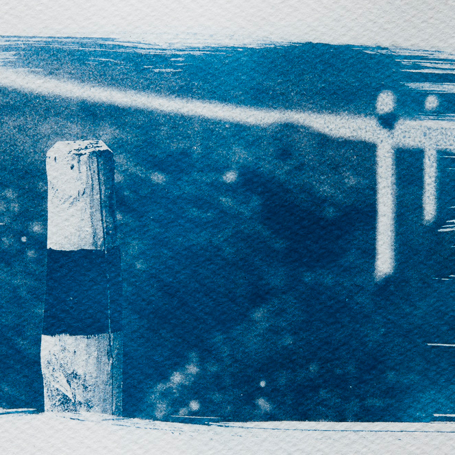 Cyanotype: three wooden reflector post with path in background