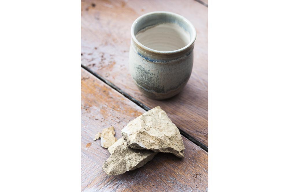 raw glaze ingredients in front of a clay pot